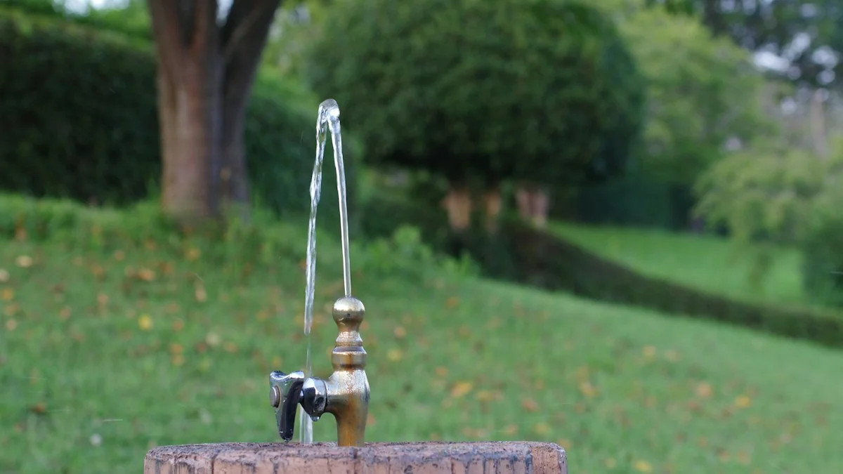 Water running from a plain outdoor tap mounted on a wooden post in a green rural field, the kind of untested private supply where coliform shows up