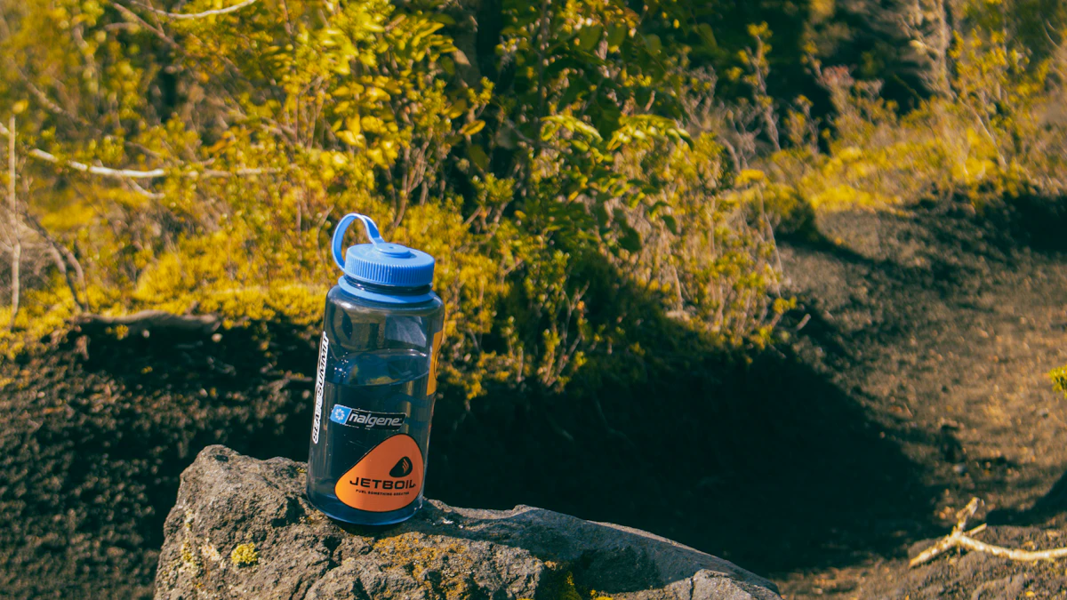 A reusable water bottle resting on a rock outdoors on a hiking trail
